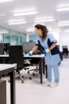 Mitarbeiterin von RWS Gebäudeservice reinigt einen Arbeitsplatz in einem modernen Büro.