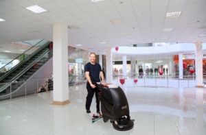 Mitarbeiter des RWS Gebäudeservice reinigt mit einer Maschine die Böden in einem Einkaufszentrum.