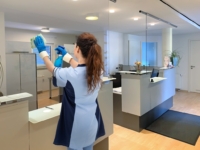 RWS Gebäudeservice Mitarbeiterin reinigt Empfangsbereich einer Arztpraxis für saubere und hygienische Oberflächen.