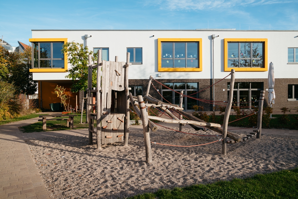 Außenbereich einer Kita mit Klettergerüst aus Holz